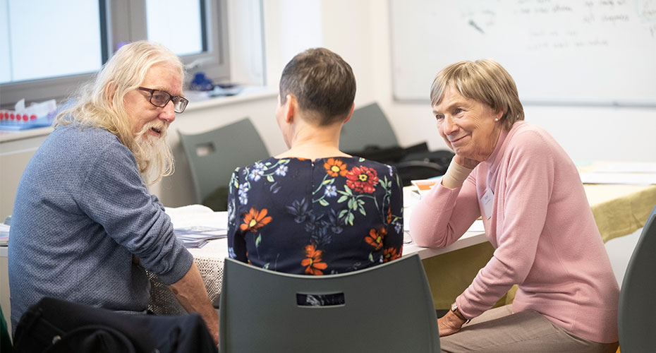 A clinician speaking to two patients