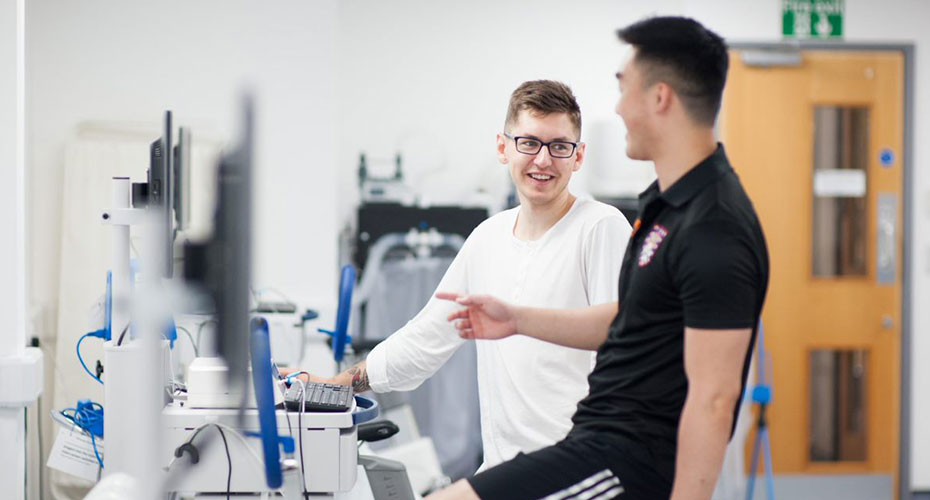 Smiling male student on exercise bike